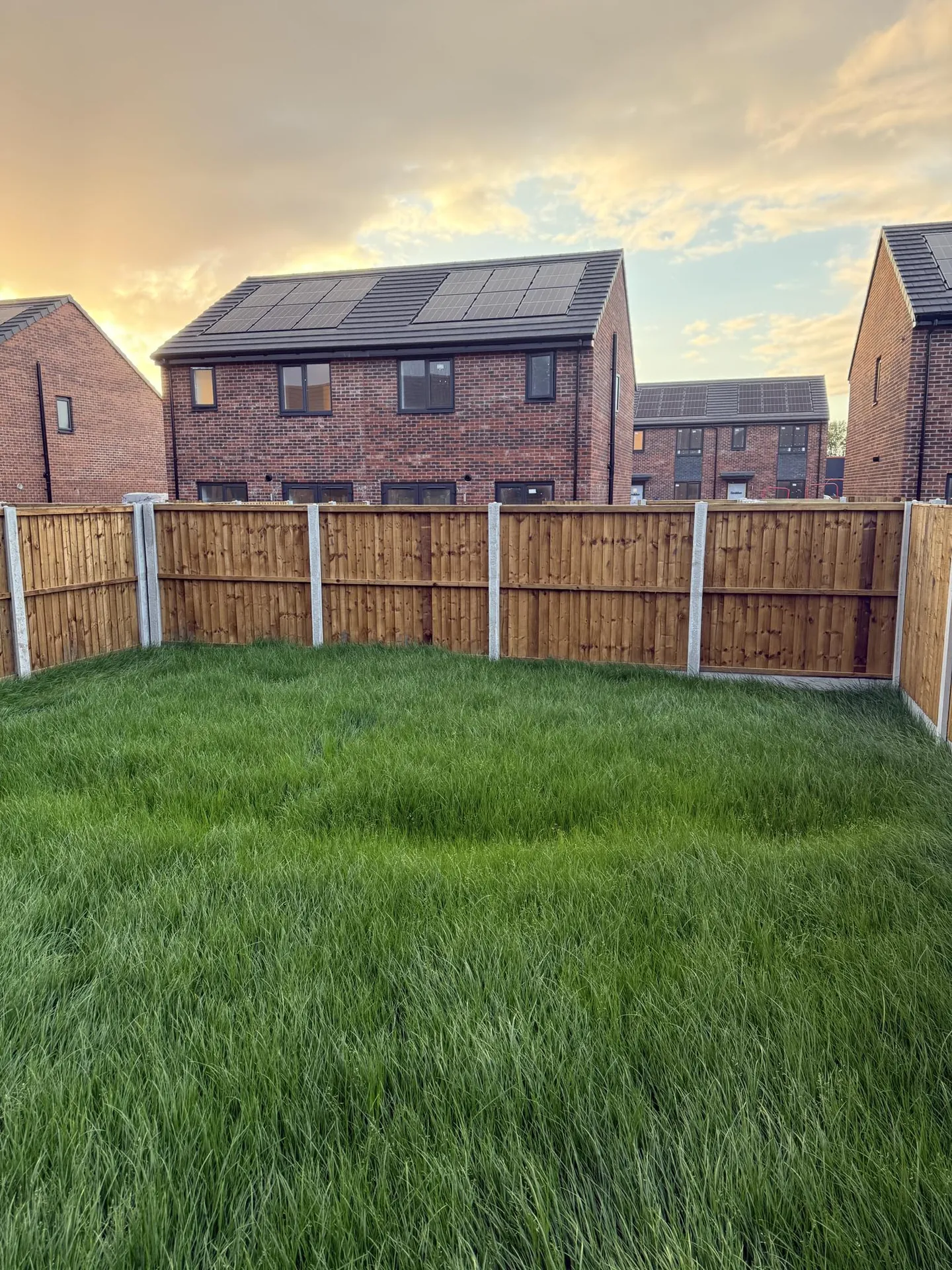 Rustic red wooden fence with a metal latch, ensuring safety and security outdoors.