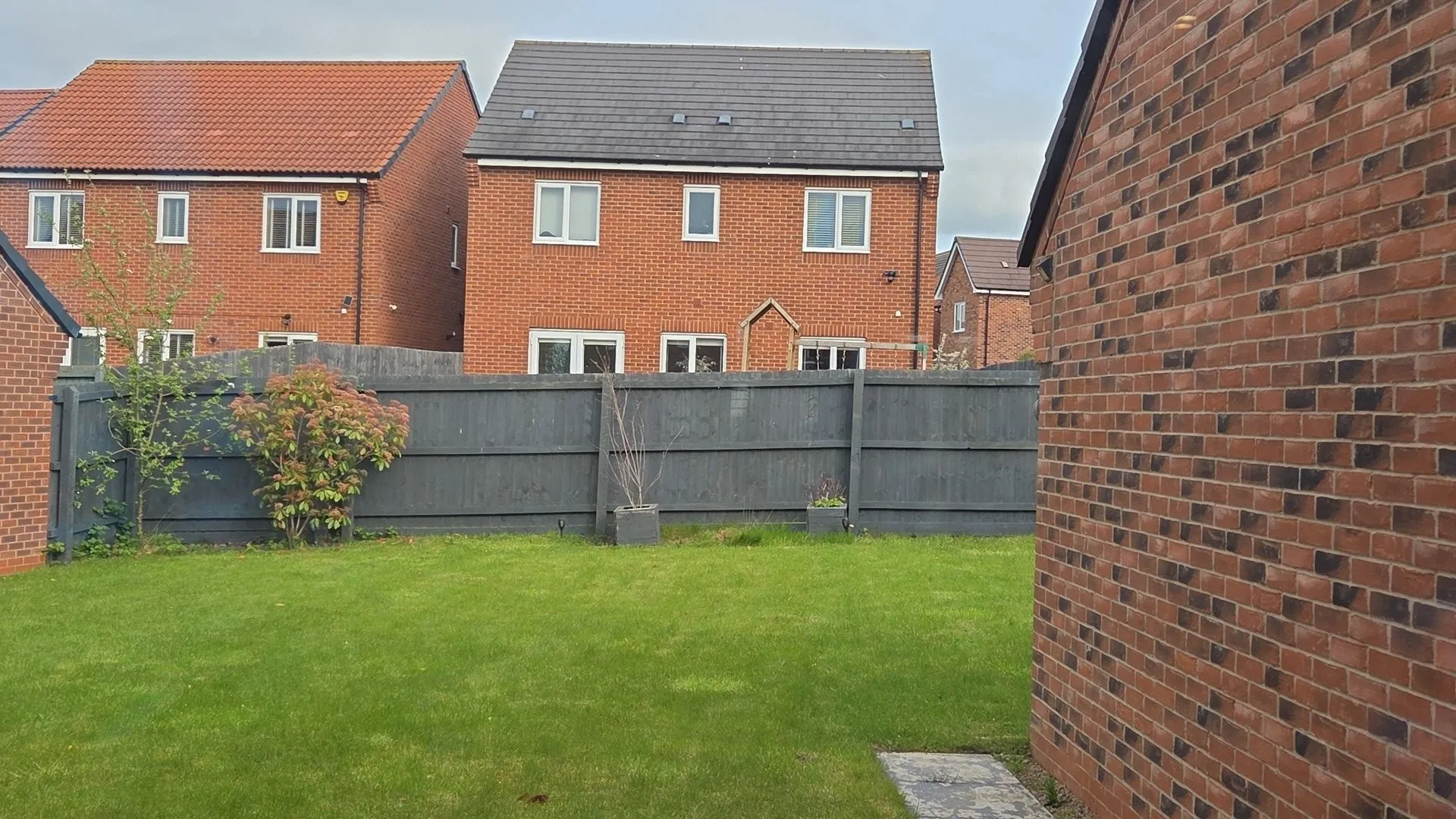 A detailed view of an ornate, rusty fence against a vibrant garden backdrop, showcasing classic design elements.